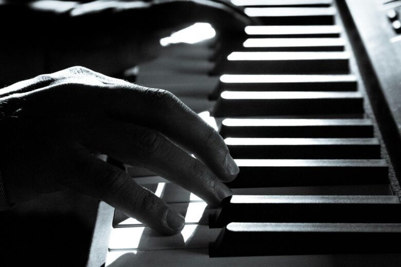 Artistic black and white photo capturing a pianist's hands on piano keys, highlighting music's emotion.